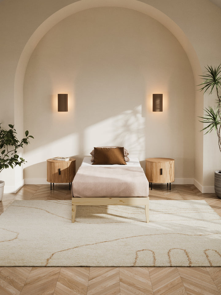 Contemporary bedroom featuring the Ventura Classic Wooden Bed Base in a clean, minimalist design. The natural light highlights the bed's sturdy construction and elegant finish, perfect for those looking to enhance their home with durable, stylish furniture. Paired with soft beige bedding and a lush view from the window, this bed base is ideal for modern décor enthusiasts.