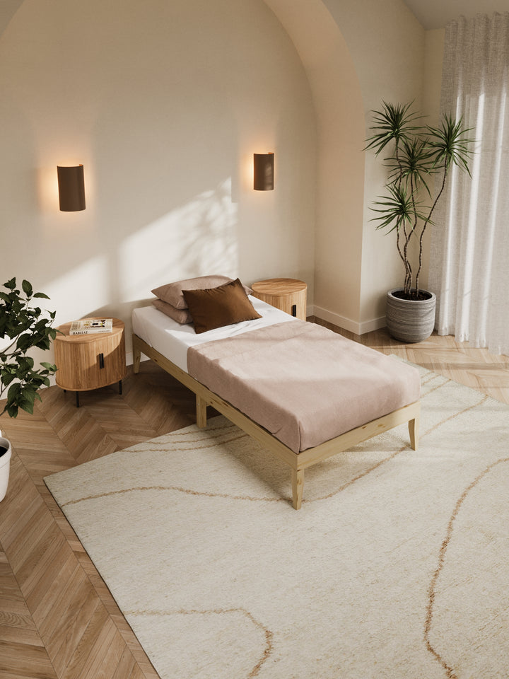 Contemporary bedroom featuring the Ventura Classic Wooden Bed Base in a clean, minimalist design. The natural light highlights the bed's sturdy construction and elegant finish, perfect for those looking to enhance their home with durable, stylish furniture. Paired with soft beige bedding and a lush view from the window, this bed base is ideal for modern décor enthusiasts.